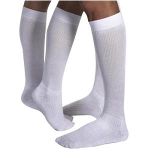 White knee-high compression socks on legs, medical support hosiery for circulation