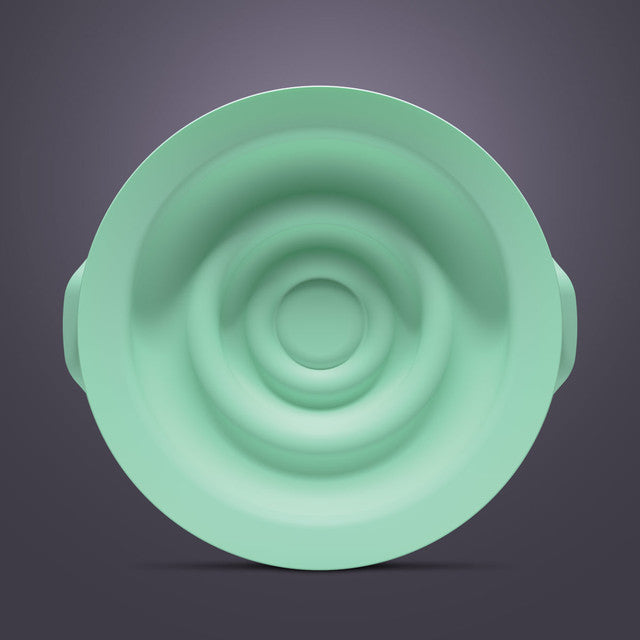 Green silicone breast pump seal with concentric ring design on a neutral background