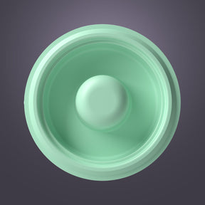 Top view of a green silicone breast pump diaphragm against a gray background