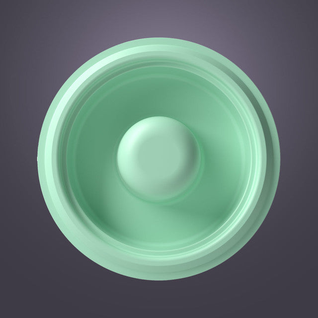Top view of a green silicone breast pump diaphragm against a gray background