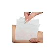 Person applying a sterile medical wound dressing pad to forearm