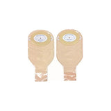 Pair of beige ostomy pouches with adhesive barrier for medical use on white background.