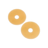 Two round beige ostomy barrier rings for medical use on a white background.