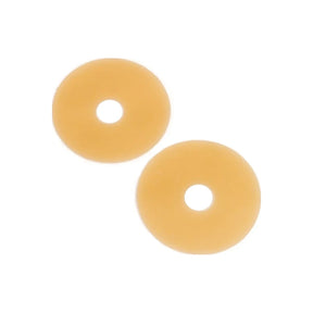 Two round beige ostomy barrier rings for medical use on a white background.