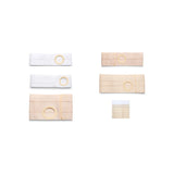 Assorted medical support belts with ostomy openings in white and beige on white background