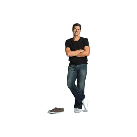 Man in casual clothing wearing white medical compression socks, standing with shoes nearby