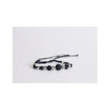 Adjustable black lava bead bracelet with silver accents on white background