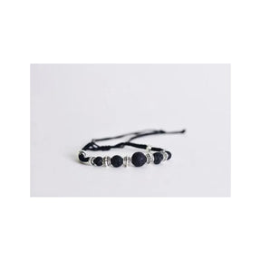 Adjustable black lava bead bracelet with silver accents on white background
