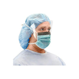Healthcare worker wearing face shield, surgical mask, blue cap, and gown for infection protection