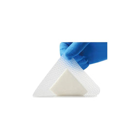 Gloved hand holding hydrocolloid wound dressing with foam pad for medical use