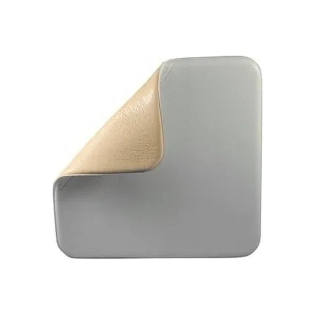 Square medical foam dressing with corner peeled back, showing adhesive wound pad