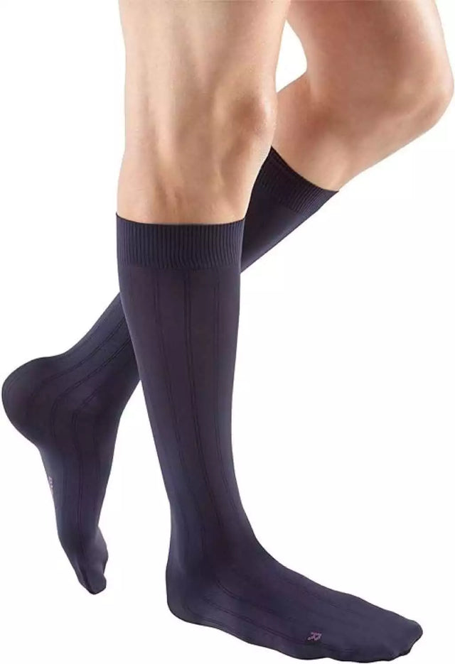 Man wearing black knee-high compression socks for medical support
