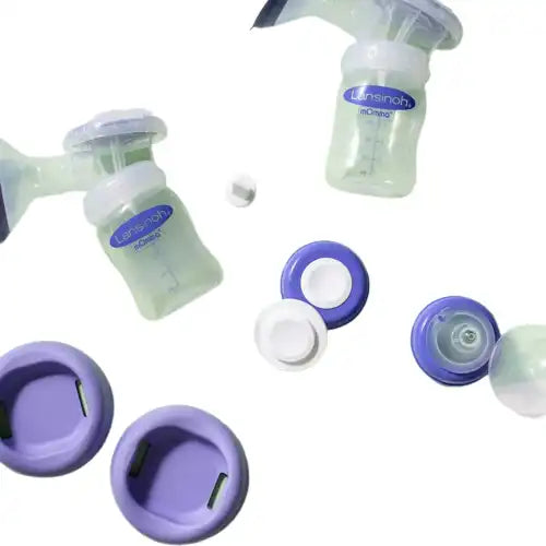 Breast pump set with bottles, lids, and purple accessories on white background