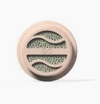 Round medical filter with beige plastic casing and porous center, home healthcare supply