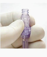 Gloved hand holding a purple medical connector for home healthcare supplies