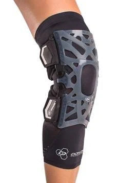 Knee wearing a black medical knee brace with open patella and adjustable support