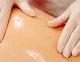 Hands in medical gloves applying ointment to skin, healthcare and medical supplies