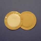 Two round adhesive medical wafers on blue background for ostomy or wound care