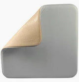 Medical foam wound dressing with adhesive edge, soft beige top layer partially peeled back