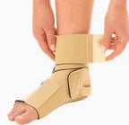 Person applying beige ankle support brace for injury recovery or foot stabilization