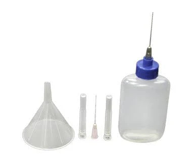 medical supply kit with plastic bottle, funnel, and needle tips on white background