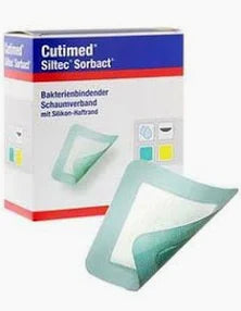 Medical foam wound dressing with silicone adhesive in front of packaging box
