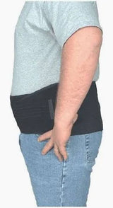 Man wearing a black medical back support belt over a t-shirt and jeans