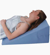 Woman lying on a blue wedge pillow for back support and comfortable sleep
