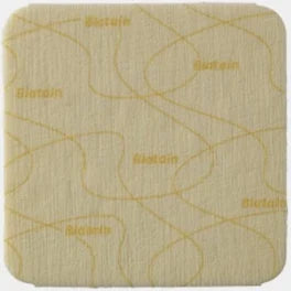 Square beige medical adhesive dressing with curved edges and printed pattern