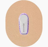 Dexcom G6 continuous glucose monitor with adhesive patch on skin-colored background