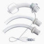 Three medical tracheostomy tubes and accessories on a white background