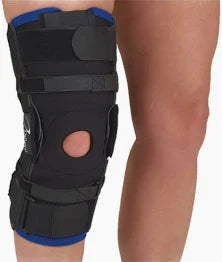 Person wearing an adjustable black knee brace for joint support and injury recovery