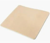 Beige medical foam dressing pad for wound care home use, square shape on white background