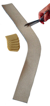 Hand cutting beige adhesive medical tape with scissors, bandage pads nearby