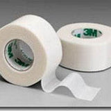 Two rolls of white medical adhesive tape on a gray background, one partially unrolled.