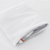 Folded white medical supply bag with orange label on a plain background