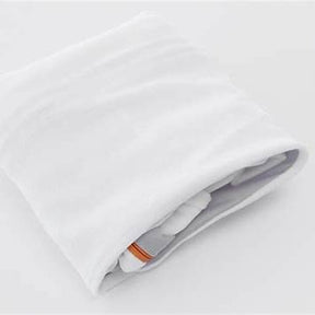 Folded white medical supply bag with orange label on a plain background