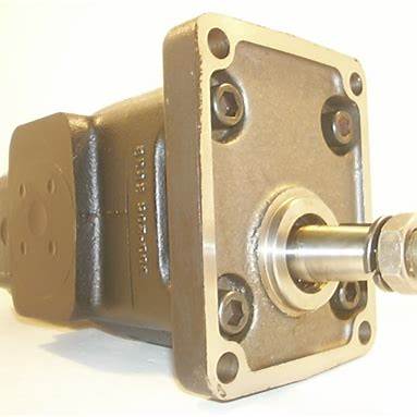 Close-up of a metal hydraulic pump with flange and shaft, industrial machine part