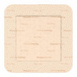 Square beige medical wound dressing with adhesive border and printed label text.
