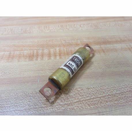 Brass cartridge fuse with metal terminals on a wood grain surface