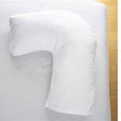 White L-shaped orthopedic pillow on a bed for medical support and comfort