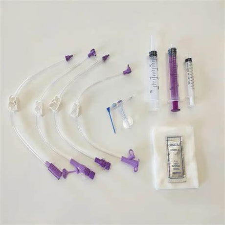Medical supply kit with syringes, extension sets, filter, and sterile gauze on white background.
