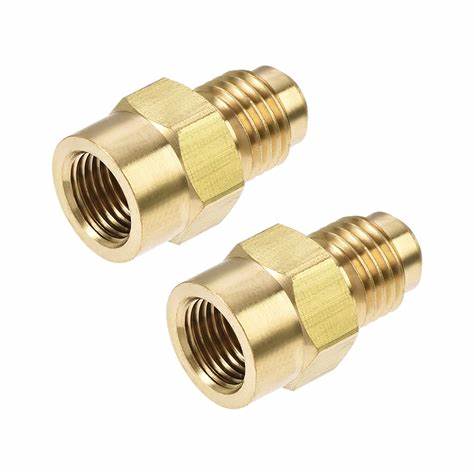 Pair of brass threaded adapters for medical equipment on white background