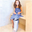 Smiling girl in bathrobe with waterproof leg cast cover sitting in bathroom